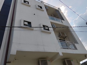 A multi-story building with balconies and air conditioning units.