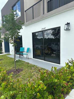 Een modern gebouw met een grote glazen deur, huisnummer 14547, en een kleine boom op de voorgrond.