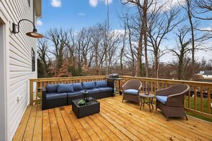 A wooden deck with a sofa, chairs, and a grill. - Beautiful 5-bedroom house in welcoming Fort Washington (Fort Washington)