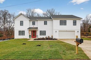 A two-story white house with a red front door, a garage, and a mailbox. - Beautiful 5-bedroom house in welcoming Fort Washington (Fort Washington)