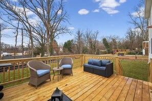 A wooden deck with wicker furniture and a blue cushion. - Beautiful 5-bedroom house in welcoming Fort Washington (Fort Washington)
