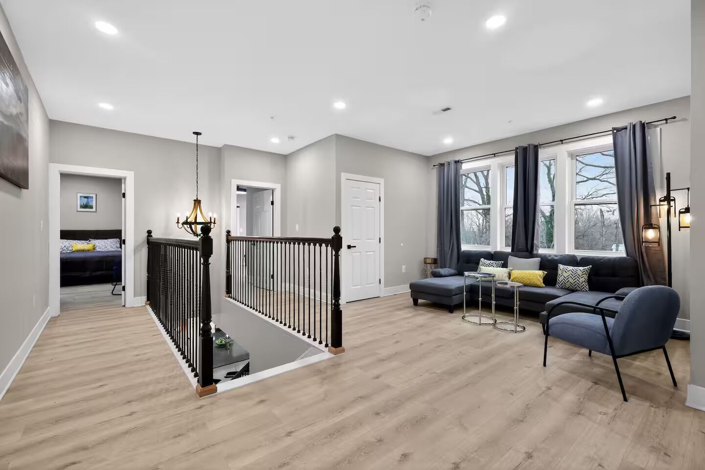 Een moderne woonkamer met een trap, een zithoek en een eethoek.