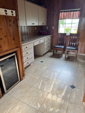 A compact kitchen with a refrigerator, cabinets, and a window with a view. - The Mossy Gambrel on Lake Huntley- fish, ski, swim, kayak and relax by fire pit! (Lake Placid)
