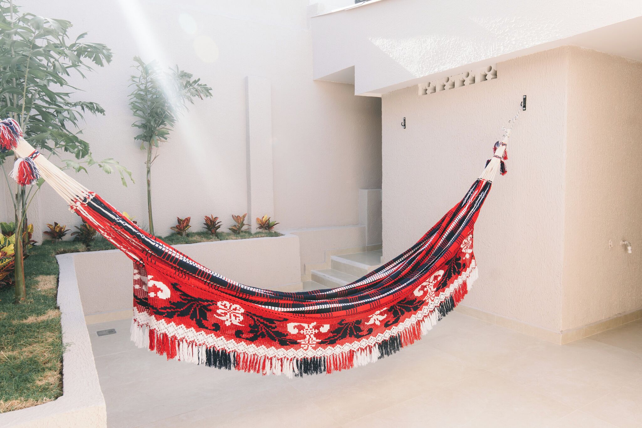 A hammock hanging between two buildings in a courtyard.