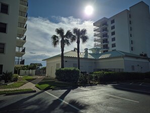 A residential building with multiple balconies, a parking area, and palm trees. - Beautiful Oceanfront condo on scenic Hutchinson Island Florida (Jensen Beach)