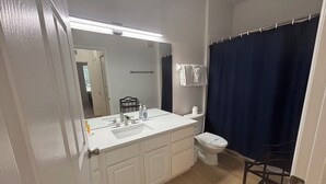 Ein Badezimmer mit Waschbecken, Spiegel und Toilette.