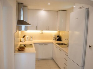 A compact kitchen with white cabinets, a built-in oven, and a stainless steel sink. - Unique villa right on the beach with its own dock. Completely renovated, Zadar (Bibinje)
