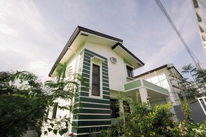 Un edificio moderno con tetto piatto, un ingresso centrale e un piccolo balcone.