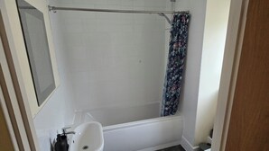Un baño con bañera, inodoro y lavamanos.