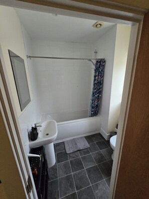Ein Badezimmer mit Badewanne, Toilette und Waschbecken.