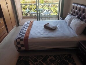Un llit amb un estenidat de quadres, un coixí i una taula de nit.