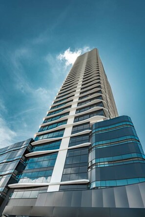 A tall, modern building with a curved facade and large windows. - Modern Furnished Studio with Ocean Views in Panama U1004 (Panamá)