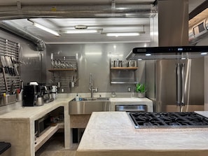 Une cuisine moderne équipée d’appareils électroménagers en acier inoxydable, d’un four encastré et d’une cuisinière à gaz.