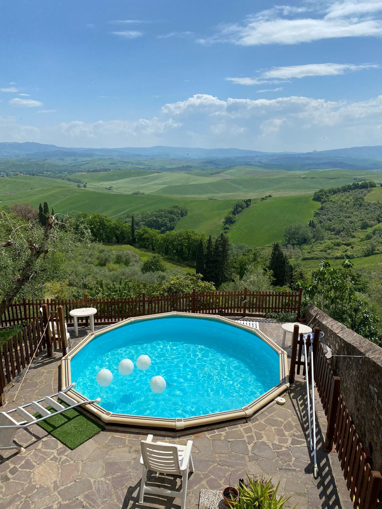 A swimming pool with a view of rolling hills and a clear sky.