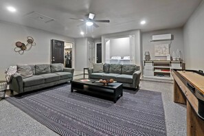 Ein Wohnzimmer mit zwei Sofas, einem Couchtisch und einem Billardtisch.