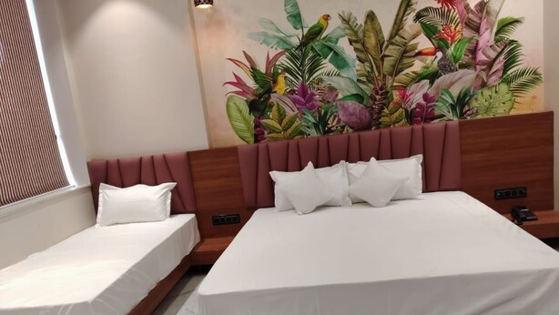 Ein Hotelzimmer mit zwei Betten, einem großen Wandgemälde im tropischen Stil und einem modernen Design.