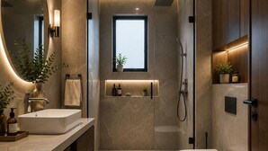 A modern bathroom with a large mirror, a freestanding bathtub, a shower enclosure, and a vanity with a sink and countertop. - Hotel Omaa Palace Managed by Vilaasitaa (Ujjain)