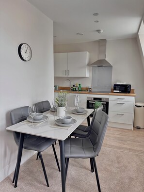 A modern kitchen with white cabinets, a microwave, and a sink.