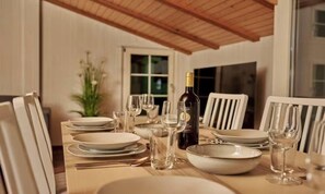 A dining table set with plates, glasses, and a bottle of wine. - CENTRAL 2-BEDROOM APARTMENT IN THE HEART OF LAUTERBRUNNEN (Lauterbrunnen)