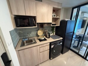 A compact kitchen with a microwave, sink, stove, and dishwasher. - 1BR Pool & WiFi⁠ @ 10 min Patong Beach & Central (Tambon Kathu)