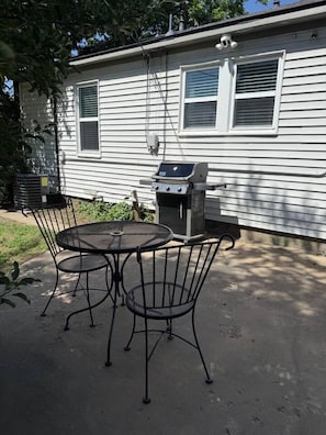 A patio with a grill and metal chairs in front of a house. - Mulberry Cottage - Your Cozy Home Away from Home (Amarillo)