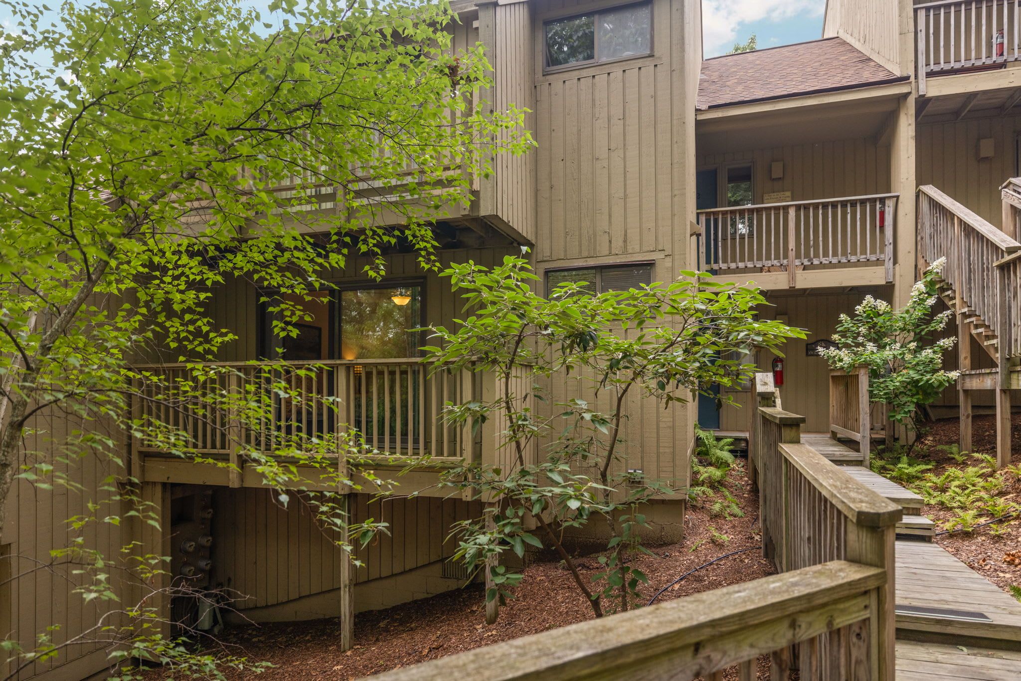 A multi-story building with wooden balconies and a wooden deck.