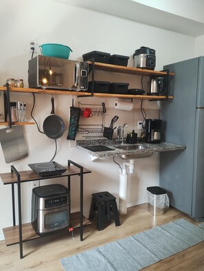 A compact kitchen with a built-in oven, a coffee maker, and a kettle on the countertop. - Fully equipped studio apartment in Rio with free parking, great location. (Rio de Janeiro)