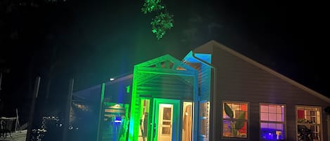 Una casa con porche y puerta visible, rodeada de árboles.