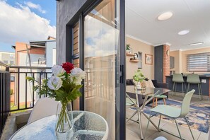 Eine moderne Wohnung mit Balkon, Essbereich und Küche.