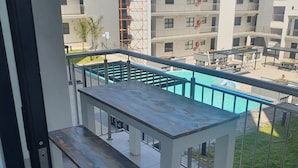 A balcony with a pool table and a pool. - Modern 2-bedroom apartment in Langebaan near the beach (Langebaan)