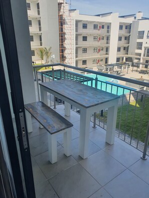 Ein Balkon mit Billardtisch und Pool.