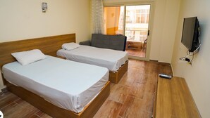 A hotel room with two single beds, a TV, and a balcony with a view. - Room-florenza Khamsin K203 Hurgada (Hurghada)