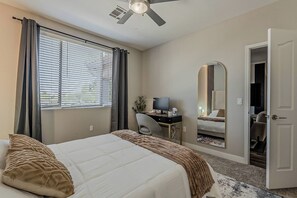 Ein Hotelzimmer mit Bett, Schreibtisch, Stuhl und Spiegel.