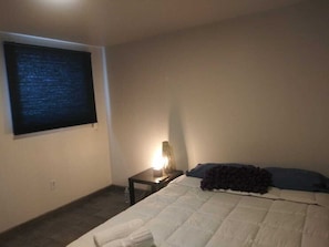 A bedroom with a bed, a nightstand, a lamp, and a window with blinds. - Pleasant 3-bedroom apartment in vibrant Tijuana perfect for your stay (Tijuana)