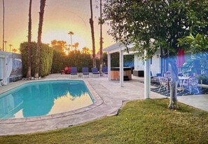 A swimming pool with a surrounding deck, lounge chairs, and a covered seating area. - Marvelous 3-bedroom house in sunny Palm Springs (Palm Springs)