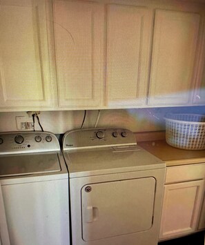 Une cuisine équipée d’une cuisinière, d’un four et d’un lave-linge.