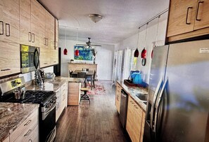 A modern kitchen with wooden cabinets, a central island, and a refrigerator. - Marvelous 3-bedroom house in sunny Palm Springs (Palm Springs)