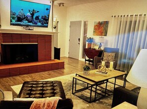 A living room with a fireplace, a television, a coffee table, and a sofa. - Marvelous 3-bedroom house in sunny Palm Springs (Palm Springs)