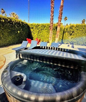 A hot tub with a built-in table and chairs, surrounded by a hedge and palm trees. - Marvelous 3-bedroom house in sunny Palm Springs (Palm Springs)