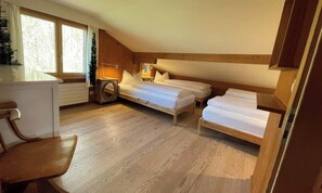 Une pièce confortable avec un plancher en bois, un lit, un bureau et une chaise.