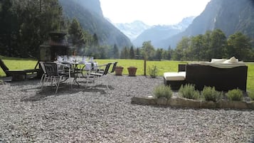 An outdoor seating area with a table and chairs, a fire pit, and a sofa.