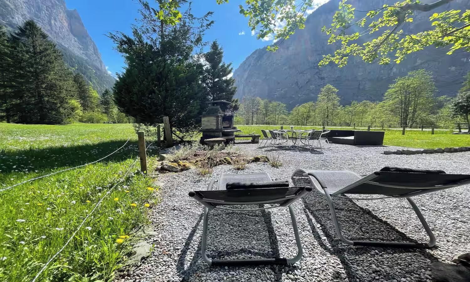 A gravel area with outdoor seating and a view of mountains.
