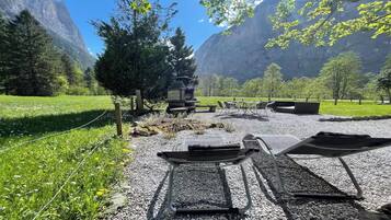 A gravel area with outdoor seating and a view of mountains.