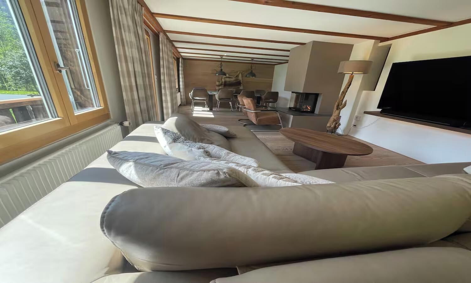 A modern living room with a sofa, a fireplace, and a television.