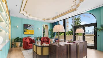 Un intérieur moderne comprenant un comptoir d’accueil, un espace détente et de grandes fenêtres offrant une vue sur le paysage urbain.