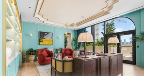 Um interior moderno com balcão de recepção, área de estar e grandes janelas com vista para a cidade.