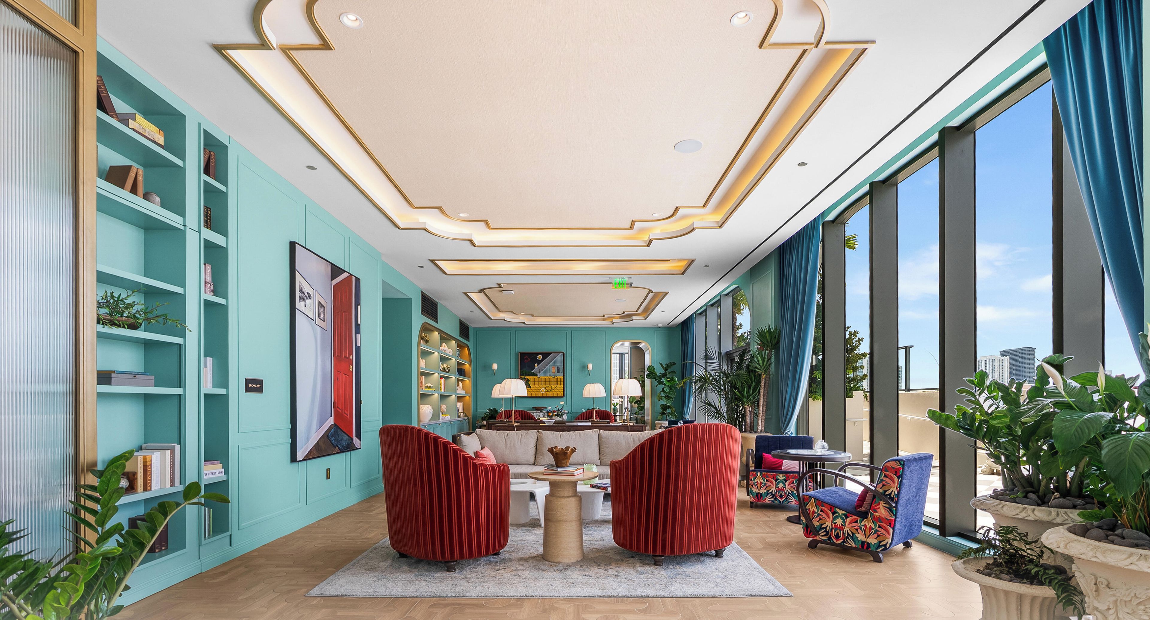 Een ruime kamer met turquoise wanden, een groot raam en een modern plafondontwerp.