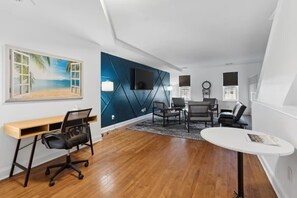 A modern office space with a wooden desk, office chair, and a round table.