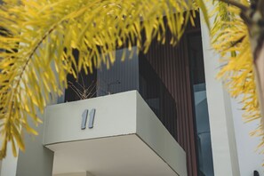 A modern building with a balcony and a sign with the number '11'. - A Hidden Refuge Where Peace Meets Serenity (Punta Cana)