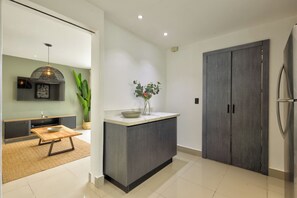 A modern kitchen with a central island, a built-in oven, and a large refrigerator. - A Hidden Refuge Where Peace Meets Serenity (Punta Cana)